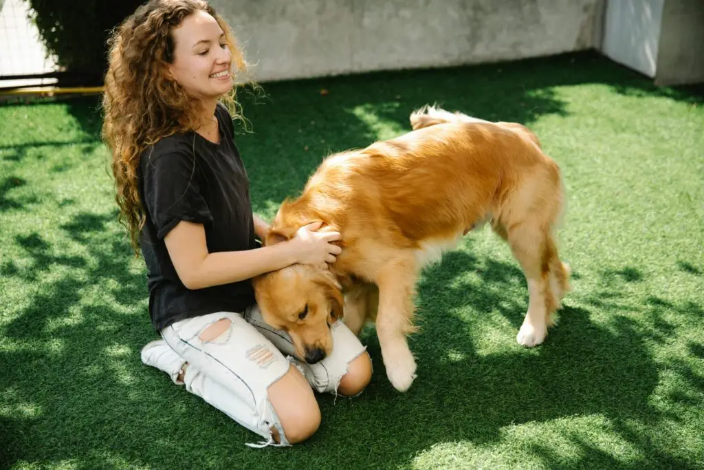 A happy pet owner playing with their dog in a clean, well-maintained yard after professional pet waste removal.